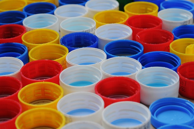 Tapas plásticas de colores organizadas, representando materiales listos para reciclaje