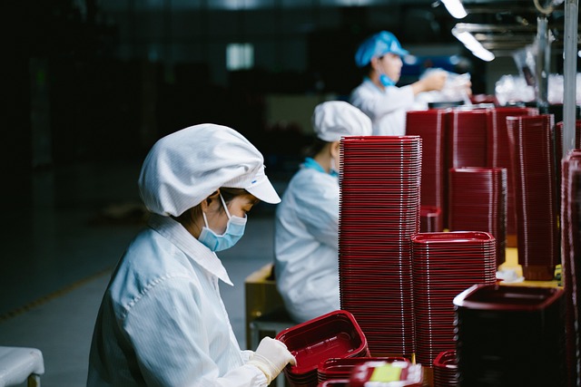Trabajadoras en una línea de producción industrial manipulando productos manufacturados